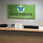 Our naturopathic clinic logo sign behind reception at True Nature Health Clinic